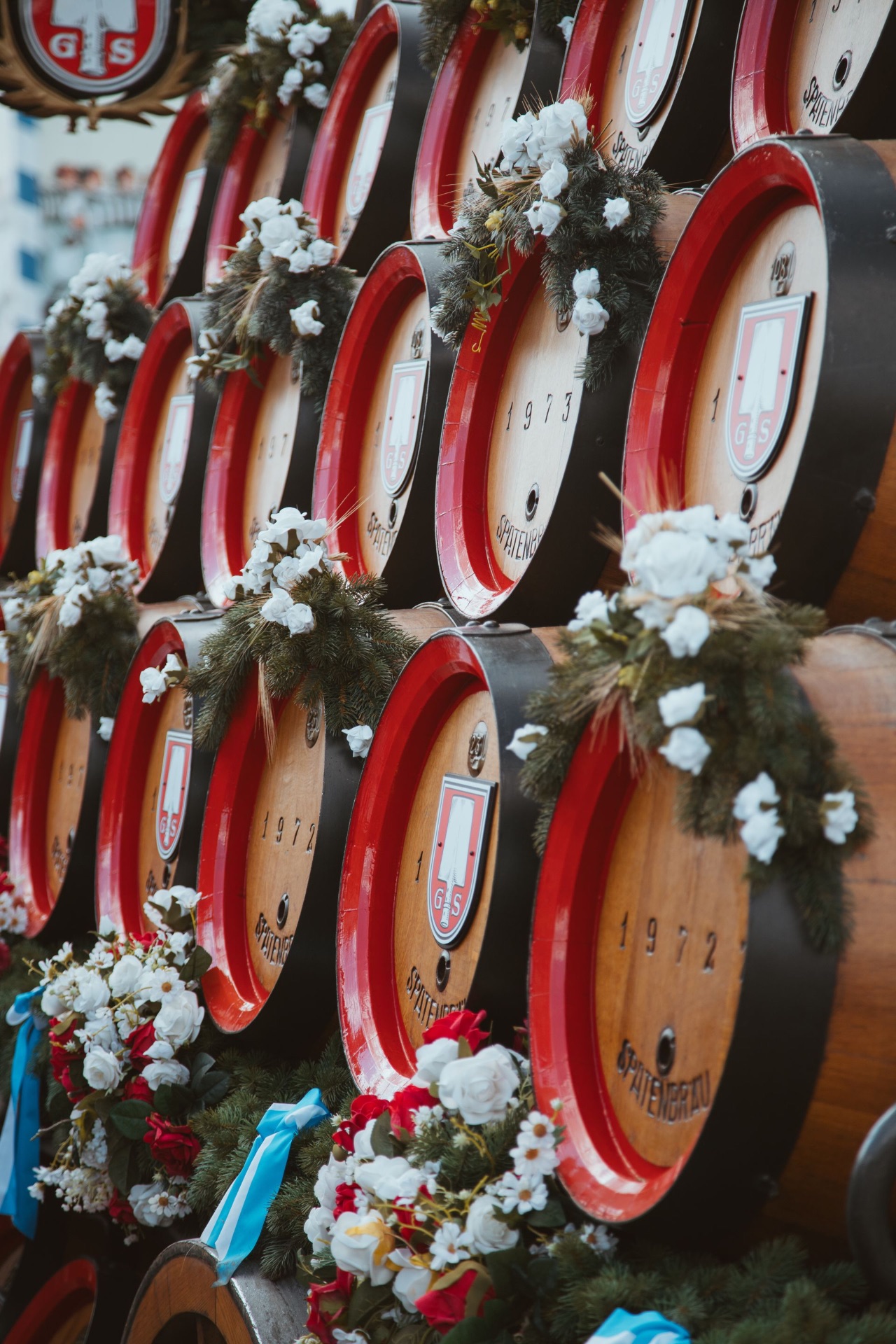Traditionelle Spaten-Brauereifässer mit Blumenschmuck und bayerischen Bändern